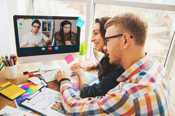 Wall Mural - Web designer talking online with colleagues from home by video call