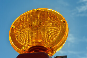 Orange traffic reflector isolated against blue sky