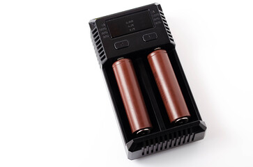 a black charger for two 18650 batteries. a green and brown 18650 battery on a white background next 