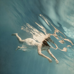 Wall Mural - Portrait of a girl in a blue dress under water  