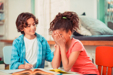 Confident boy cheering up his female classmate