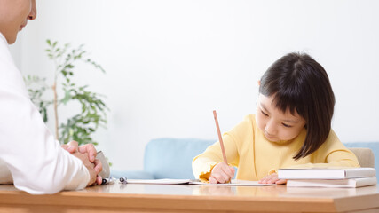 家庭教師と勉強する小学生