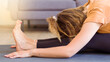 Young woman with curly hair doing yoga exercise at home on the floor