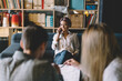 © BullRun - Joyful young woman having phone conversation while thoughtful colleagues working with papers in modern office