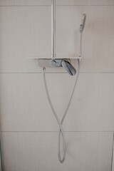 Canvas Print - Vertical shot of the shower attached to the wall in a modern bathroom