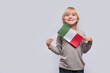 © somemeans - Happy blond boy holding flag of Italy on white background. Education in Italy