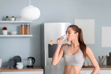 Sticker - Beautiful young woman drinking water in kitchen