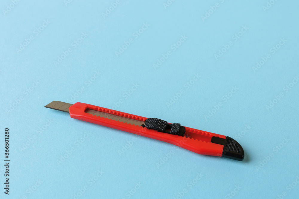 Small Red Box Cutter Box cutter or utility knife with red handle on a blue background. Paper ...