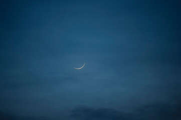 crescent moon in the dusk with blue sky