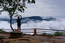 Tourists Taking Pictures Of The Scenery At The Viewpoint Of The Cliff That Has Fog Around The Mountain. Pha Mo E Dang, Thailand