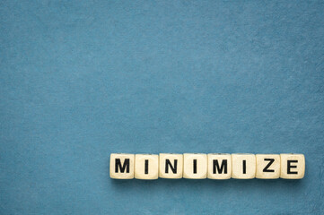 minimize word in wooden cubes against handmade textured rag paper with a copy space, simplicity, min