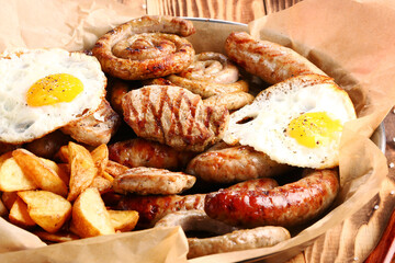 bavarian sausage plate with potatoes and fried egg. Grilled sausages closeup. Top view with copy space Appetizing beer snacks set.