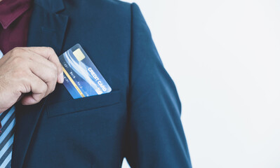 Businessman's hand put a credit card into a smart blue suit pocket