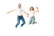 © LIGHTFIELD STUDIOS - happy adult couple in white t-shirts holding hands while jumping isolated on white