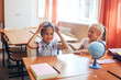© Anastassiya  - Two schoolgirls are sitting at a school desk, back to school, teaching children
