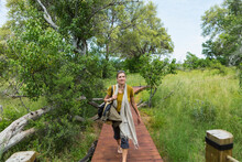 Adult Woman Walking Wooden Path, Tented Camp, Botswana