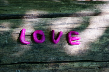 Sticker - The inscription love on the wooden surface.