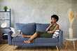 © Сергей Уланов - Unhappy African American woman talking on the phone, angry girl talking on the phone, discharged or broken mobile device, problem with phone, sitting on sofa