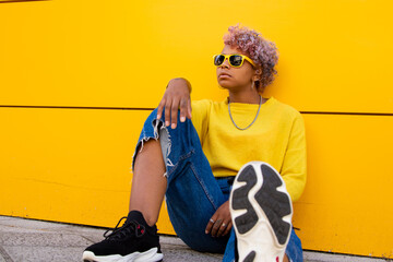 Wall Mural - young girl with sunglasses sitting on the city street