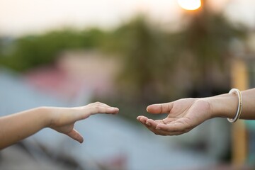 Wall Mural - Shallow focus shot of the hands of two people reaching out to one another