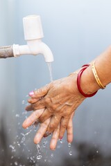 Poster - Female washing hands under the faucet - importance of washing hands during the COVID-19 pandemic