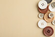 © New Africa - Many colorful sewing buttons on beige background, flat lay. Space for text