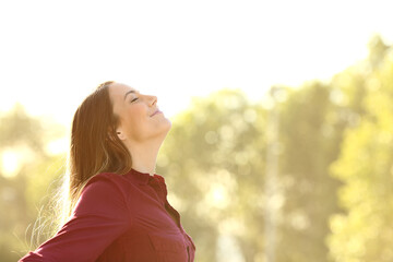 Poster - Relaxed woman breathing fresh air outdoors on a park