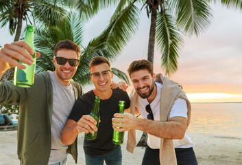 Poster - friendship and leisure concept - group of happy young men or male friends toasting non alcoholic beer over tropical beach background in french polynesia