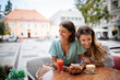 © NDABCREATIVITY - Technology, friendship and people concept. Happy young women with smartphone at outdoor cafe