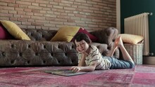 4k Video Footage Of An Adorable Little Boy Looking At A Playing Cards Album On The Carpet, At Home. Slow Camera Movement.