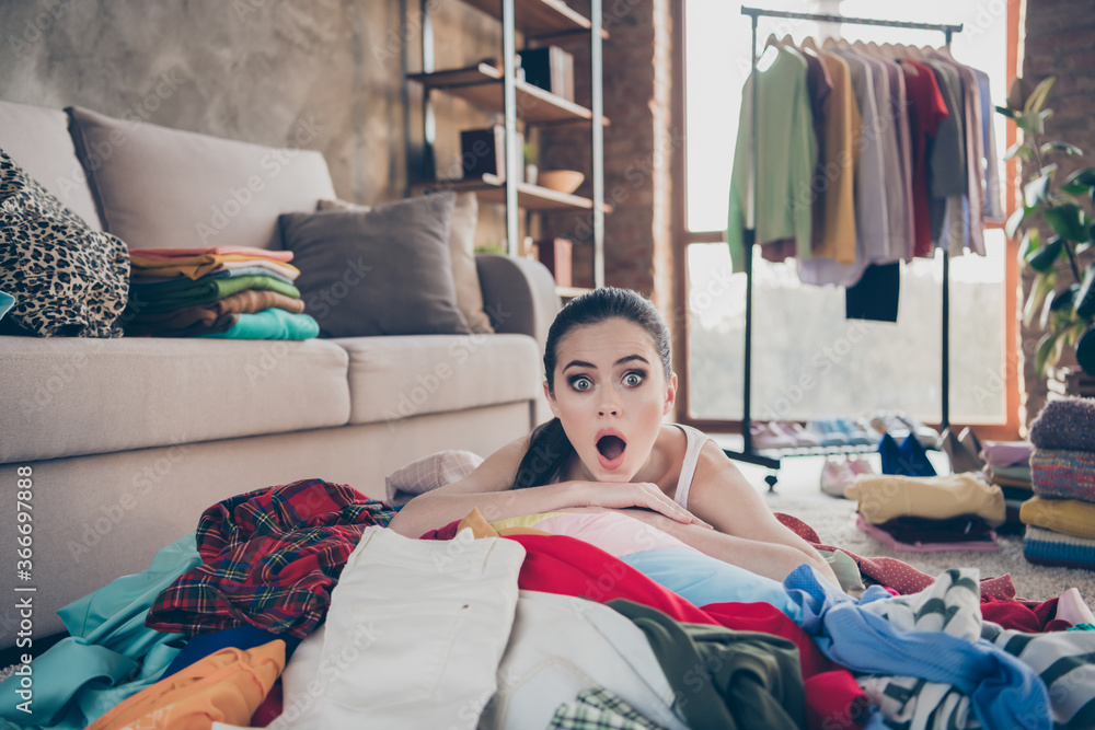 Photo of pretty displeased lady stay home quarantine lying many clothes heap stack floor wardrobe stuff pick select date look outfit confused have nothing to wear living room indoors - obrazy, fototapety, plakaty 
