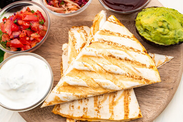 Mexican traditional authentic homemade quesadilla with pulled pork beef chili con carne serve with tomato salad and avocado guacamole and dip sauce