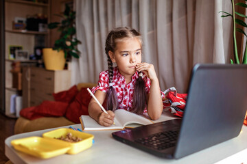 Wall Mural - Distant education, back to school. Girl studying homework during online lesson at home