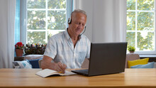 Focused Mature Businessman Wear Headphones Study Online Watching Webinar