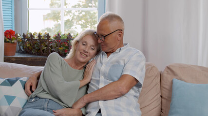 Retired mature couple sitting on couch together and relaxing