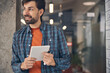 © Svitlana - Cheerful young man with tablet computer standing in office