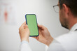 © veles_studio - doctor holding green screen smartphone