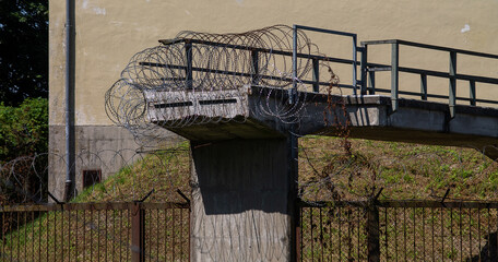 A cut-off bridge solidly secured with barbed wire against ingress.