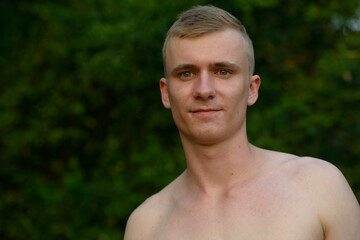 Wall Mural - Young man with blond hair shirtless at the park outdoors