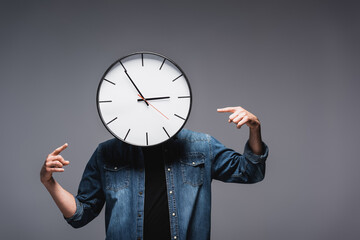 Wall Mural - Man with clock near face pointing with fingers on grey background, concept of time management