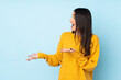 © luismolinero - Young caucasian woman isolated on blue background with surprise expression while looking side