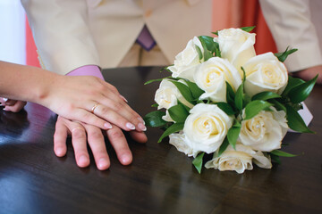 Wall Mural - hands of the bride and groom with gold rings at the wedding