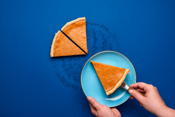 Pumpkin pie slice above view. Serving a slice of pumpkin tart on a blue plate