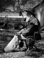 A senior cowboy sat with a gun to guard the safety of the camp in the western area