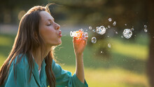 Beautiful Girl Blowing Soap Bubbles