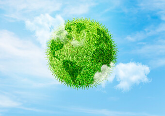 Green Earth Concept : Green grass planet earth in sphere shape with blue sky and white clouds in background.