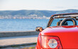 Red car on the seashore in the evening.