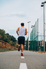 Wall Mural - Young fitness man running in urban area