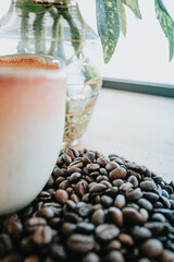 Wall Mural - Close view of a cup of coffe, grains of coffe and a plant