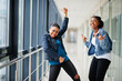 © AS Photo Family - Two african woman friends in jeans jacket show rock fingers  indoor together.